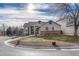 Tan house with blue accents, a large yard, and a curved driveway at 9318 W Coal Mine Ave, Littleton, CO 80123