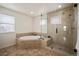 Luxurious bathroom featuring a separate bathtub, glass enclosed shower, and tile flooring at 6276 S Robertsdale Ct, Aurora, CO 80016