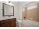 Bathroom features a tiled shower-tub, granite countertops, and warm wood cabinetry at 6276 S Robertsdale Ct, Aurora, CO 80016