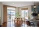 Bright dining area with hardwood floors, ample natural light, and a view into the modern kitchen at 6276 S Robertsdale Ct, Aurora, CO 80016
