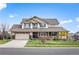 Charming two-story home with a wide front porch, attached two-car garage, and landscaped yard at 6276 S Robertsdale Ct, Aurora, CO 80016