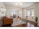 Bright living room featuring a brown leather sofa, stylish chairs, patterned rug, and hardwood floors at 6276 S Robertsdale Ct, Aurora, CO 80016