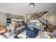 Open living room with a view of the kitchen and staircase, featuring comfortable seating and hardwood floors at 6276 S Robertsdale Ct, Aurora, CO 80016