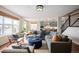 Open-concept living space with hardwood floors and comfortable seating near the kitchen and stairway at 6276 S Robertsdale Ct, Aurora, CO 80016