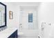 Bright bathroom with a shower over bath, and blue vanity at 3801 S Albion St, Englewood, CO 80113
