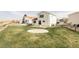 Expansive backyard with lush green grass, a unique circular concrete pad, and a charming rustic wooden fence at 9665 Bighorn Way, Littleton, CO 80125
