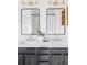Bathroom featuring double sinks with dark cabinets, modern faucets, and framed mirrors at 9665 Bighorn Way, Littleton, CO 80125