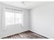 Minimalist bedroom with wood-look flooring and a bright window at 9665 Bighorn Way, Littleton, CO 80125