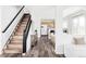 Spacious foyer features hardwood floors, staircase, and an open view into the modern kitchen at 9665 Bighorn Way, Littleton, CO 80125