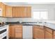 Bright kitchen featuring wood cabinets, white appliances, and a view from the window at 9665 Bighorn Way, Littleton, CO 80125
