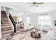 Bright living room with stairs, hardwood floors, and seamless connection to the modern kitchen and dining area at 9665 Bighorn Way, Littleton, CO 80125