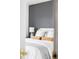 Main bedroom featuring a bed with decorative pillows and a gray accent wall at 9665 Bighorn Way, Littleton, CO 80125