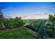 Scenic backyard view with lush greenery, mature trees, and distant mountain views at 11362 W Baltic Ct, Lakewood, CO 80227