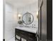 Stylish powder room with a black vanity, marble countertop, and decorative wallpaper at 11362 W Baltic Ct, Lakewood, CO 80227