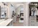 Modern bathroom with a sleek vanity, stylish mirror, and a view through to the bedroom and walk-in closet at 11362 W Baltic Ct, Lakewood, CO 80227