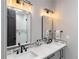 Contemporary bathroom with double vanity, sleek mirrors, and walk-in shower at 11362 W Baltic Ct, Lakewood, CO 80227