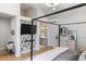 Spacious bedroom featuring modern decor, a four-poster bed, and a connected bathroom with double vanity sinks at 11362 W Baltic Ct, Lakewood, CO 80227