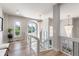 Well-lit hallway with hardwood floors, modern chandeliers, and glass railings at 11362 W Baltic Ct, Lakewood, CO 80227