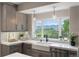 Charming kitchen featuring light wood cabinets, a farmhouse sink, and a scenic view from the window at 11362 W Baltic Ct, Lakewood, CO 80227