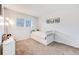 Bright bedroom featuring a window, light gray walls, and neutral carpet at 1294 S Troy St, Aurora, CO 80012