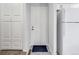 Clean entryway featuring a white door, neutral flooring, and closet space, with a white refrigerator at 1294 S Troy St, Aurora, CO 80012