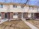 Charming townhome featuring a brick facade, tidy landscaping, and a concrete walkway leading to the front door at 1294 S Troy St, Aurora, CO 80012