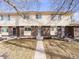 Charming townhome featuring a brick facade, tidy landscaping, and a concrete walkway leading to the front door at 1294 S Troy St, Aurora, CO 80012