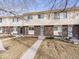 Charming townhome featuring a brick facade, tidy landscaping, and a concrete walkway leading to the front door at 1294 S Troy St, Aurora, CO 80012