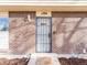 Close-up of the front door with brick surround, security gate, and visible house number at 1294 S Troy St, Aurora, CO 80012