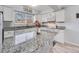 Bright kitchen features white cabinetry, granite countertops, stainless steel sink, and modern appliances at 1294 S Troy St, Aurora, CO 80012