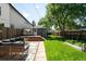 Landscaped backyard featuring a cozy patio area, lush lawn, and charming outdoor seating at 3842 Zenobia St, Denver, CO 80212
