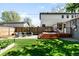 Well-manicured backyard with patio, deck, modern furniture, and lawn at 3842 Zenobia St, Denver, CO 80212