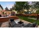 Relaxing backyard setting featuring outdoor seating, lush greenery, and a wooden deck at 3842 Zenobia St, Denver, CO 80212