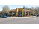 Exterior of yellow Queen City Collective with dining tables outside on a sunny day at 3842 Zenobia St, Denver, CO 80212