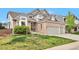 Charming two-story home featuring a brick facade, a well-manicured lawn, and a spacious two car garage at 8958 Forrest Dr, Highlands Ranch, CO 80126