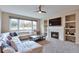 Cozy living room features a fireplace, built-in shelves, plush carpet, and a large sectional couch at 8958 Forrest Dr, Highlands Ranch, CO 80126