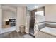 This main bathroom has a gray tiled shower, a soaking tub and access to the main bedroom at 8958 Forrest Dr, Highlands Ranch, CO 80126