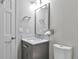 This powder room has gray walls, a gray vanity with marble countertop and a white toilet at 8958 Forrest Dr, Highlands Ranch, CO 80126
