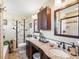 Bathroom featuring a double sink vanity, granite countertop, and tiled shower at 6500 S Downing St, Centennial, CO 80121