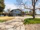 Exterior view showing a gray two-story home, large driveway, and mature trees at 6500 S Downing St, Centennial, CO 80121