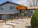 Close-up of the home's front entrance with a covered porch, stone landscaping, and green door at 6500 S Downing St, Centennial, CO 80121