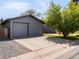 Large gray garage with ample driveway and landscaping; close to the road at 6500 S Downing St, Centennial, CO 80121