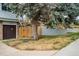 Garage beside yard featuring a mature tree, wood fence, and concrete foundation at 9967 Lane St, Thornton, CO 80260