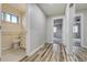 Hallway leading to updated bathroom with a white vanity and adjacent bedroom at 9967 Lane St, Thornton, CO 80260