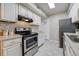Well-lit kitchen with white cabinetry, stainless steel appliances, and a sleek black oven range at 9967 Lane St, Thornton, CO 80260