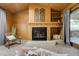 Living room with wood-paneled walls, vaulted ceiling, and brick fireplace with decorative accents at 9967 Lane St, Thornton, CO 80260
