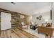 Living room with wood-look accent wall, modern decor, and an open floor plan at 9967 Lane St, Thornton, CO 80260