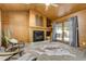 Living room boasts wood paneling, brick fireplace, and sliding door access to the backyard deck at 9967 Lane St, Thornton, CO 80260