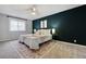 Comfortable bedroom with a dark accent wall, plush bedding, and soft natural light at 9967 Lane St, Thornton, CO 80260