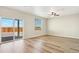 Bright room with wood-look floors, a ceiling fan, large sliding glass doors, and an abundance of natural light at 9484 Yampa St, Commerce City, CO 80022